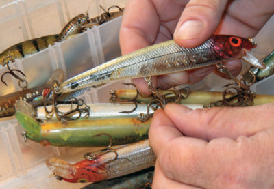 Image d'un homme nettoyant les leurres utilisés lors de la saison de pêche précédente.