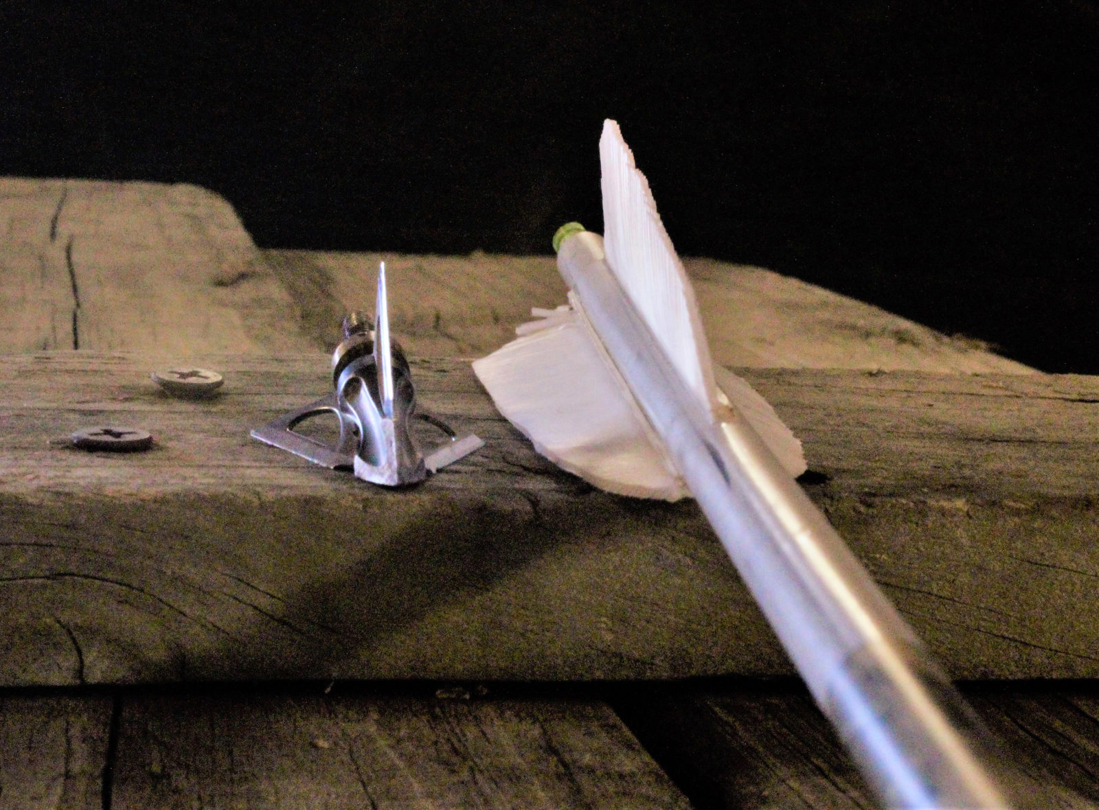 Image d'une lame et d'un empennage de flèche sur une clôture en bois