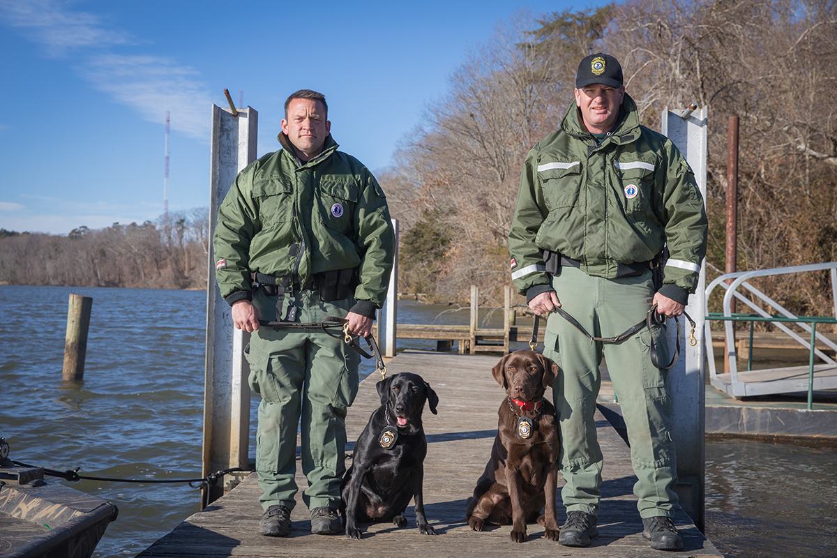 Le CPO James Patrillo et K9 Bailey (à gauche) et le CPO Wes Billings et K9 Molly sur un quai.
