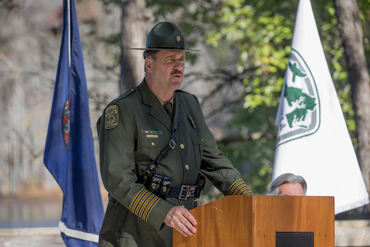 Le colonel John J. Cobb, chef de la police du DWR, s'exprime depuis un pupitre en bois lors de la cérémonie.