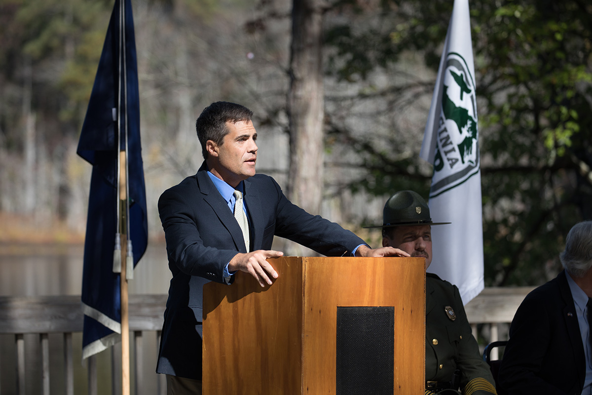 Image du directeur exécutif du DWR, Ryan Brown, s'exprimant depuis un podium en bois lors de la cérémonie d'inauguration.