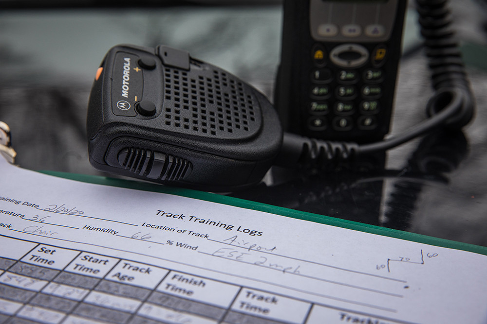 Image d'une unité GPS, d'un dispositif de communication et d'un carnet de suivi sur une table en verre.