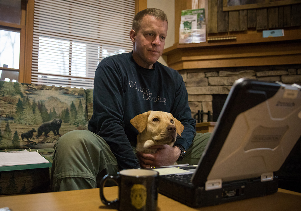 Lily, le labrador jaune, et Mark Diluigi, officier de police judiciaire, examinent les images de suivi.