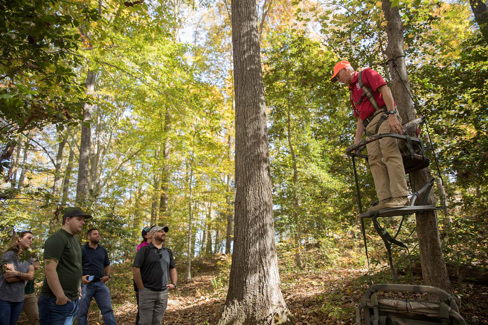 Plusieurs personnes regardent un instructeur de formation à la chasse faire des démonstrations de sécurité dans les miradors.