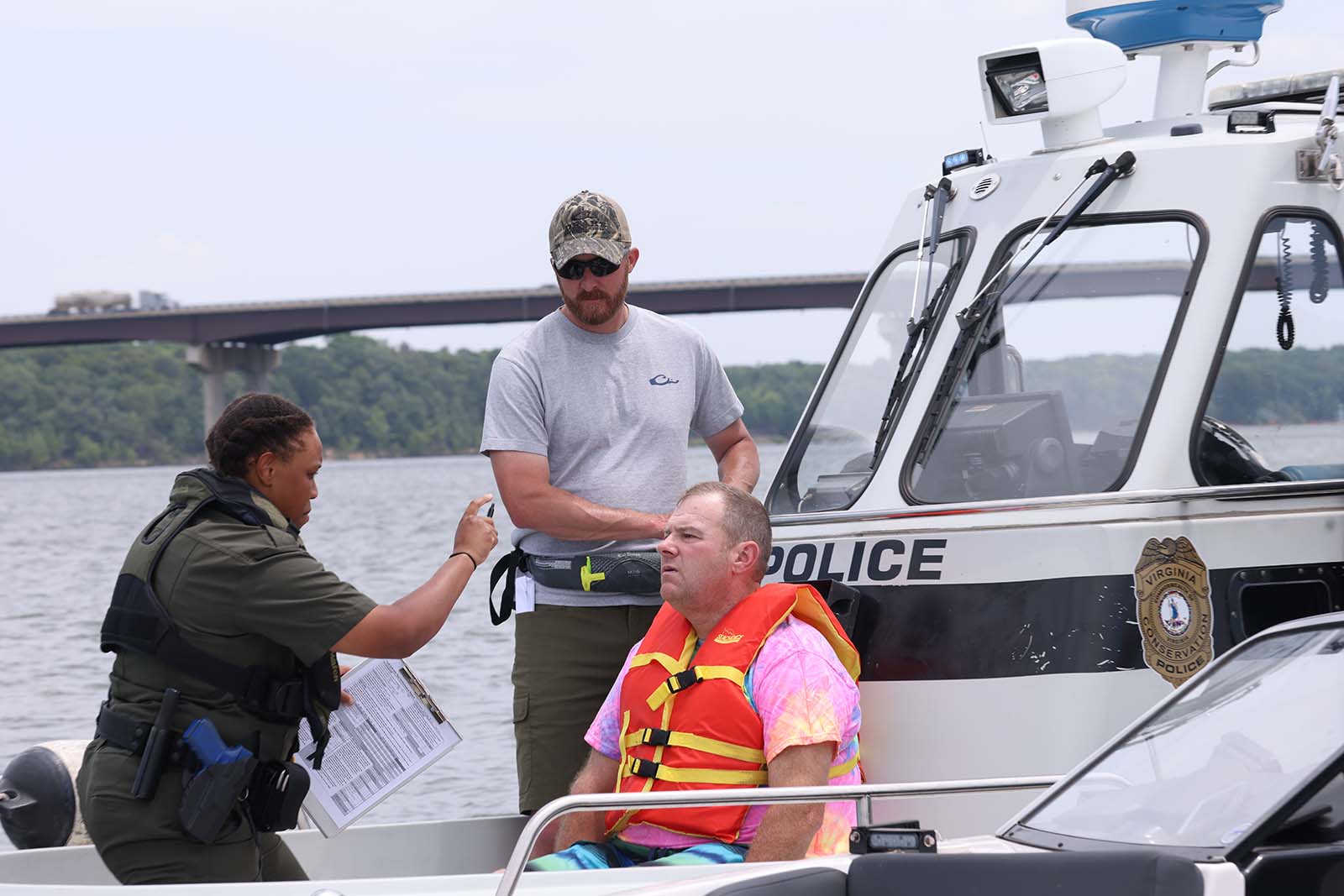 Un agent de la police de la conservation soumet un plaisancier à un test de sobriété sur le terrain.