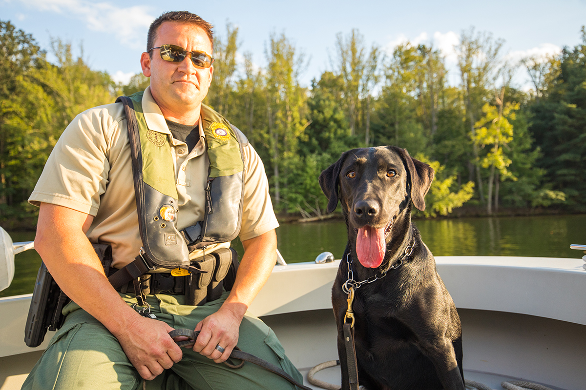 CPO Jim Patrillo et K9 Bailey le labrador noir sur un bateau