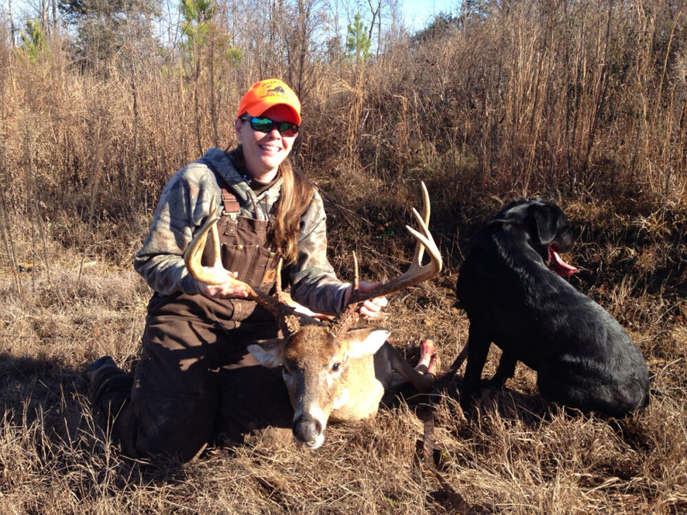 Le sergent Jessica Whirley et un cerf qu'elle a abattu, posant à côté de son labrador.