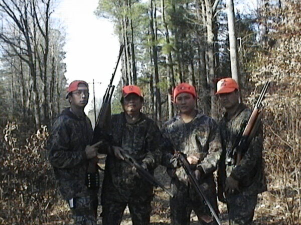 La famille Culanding chassant ensemble dans une forêt de feuillus