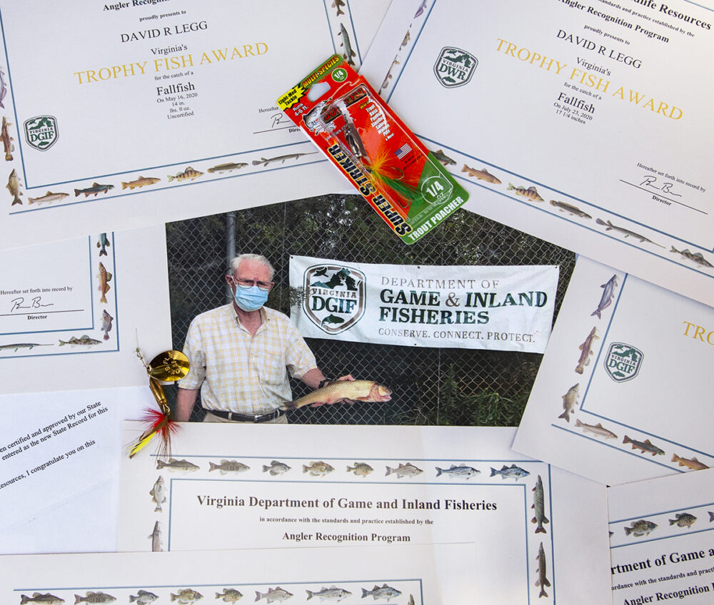 Une image du pêcheur qui a attrapé le fallfish record, entouré d'une multitude de récompenses qu'il a gagnées au fil des ans.