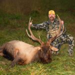 Un homme souriant, posant avec un élan mort.