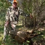 Un homme posant avec un élan mort, chassé.