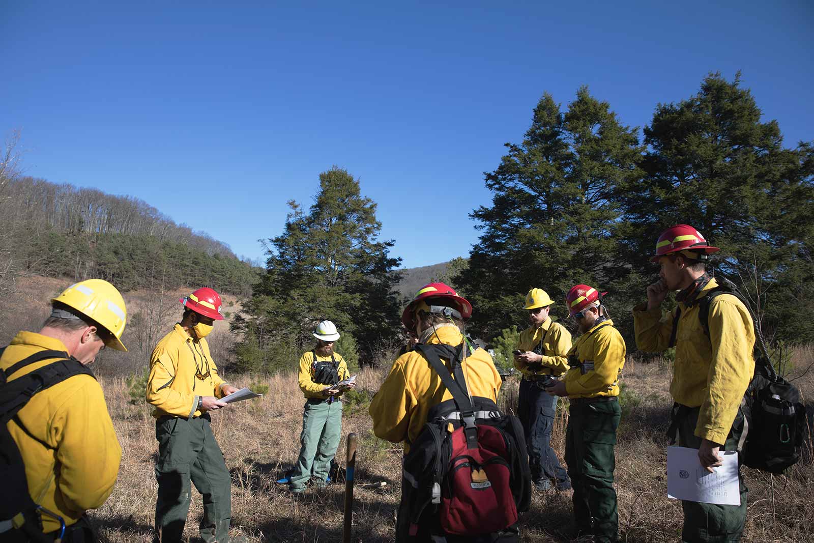 Une équipe de pompiers se réunit pour examiner le plan de brûlage dirigé de la journée.