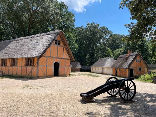 Photo d'une reproduction moderne de la colonie de Jamestown, montrant des bâtiments à l'arrière-plan et un canon au premier plan.