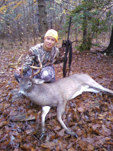 Un homme pose avec un cerf qu'il a tué