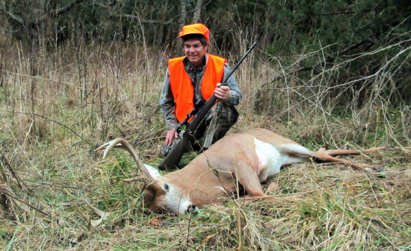 Image d'un chasseur posant avec un mâle mort