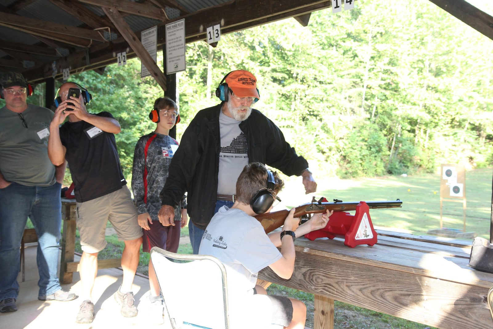 Photo d'un garçon apprenant à tirer avec une arme à feu