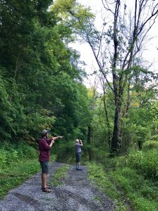 Deux personnes faisant de l'ornithologie dans une forêt de feuillus