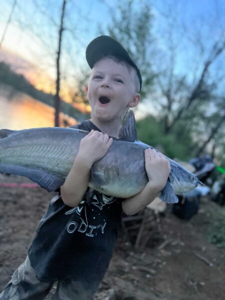 Dallas (age 5), tenant un poisson avec ses deux bras