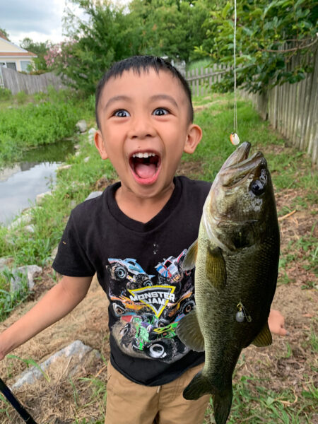 Un jeune garçon, âgé de 5, posant avec un poisson.