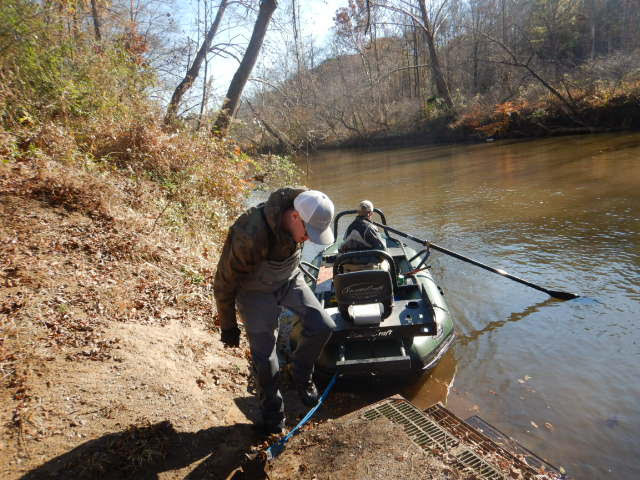 Le radeau de pêche électrique vert est débarqué de la terre ferme avec deux employés.