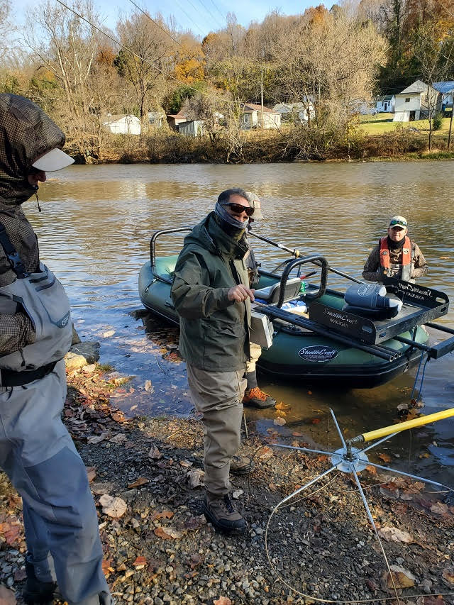 Quatre hommes autour du bateau de pêche électrique habillés pour le froid lors de l'échantillonnage des poissons à l'automne.