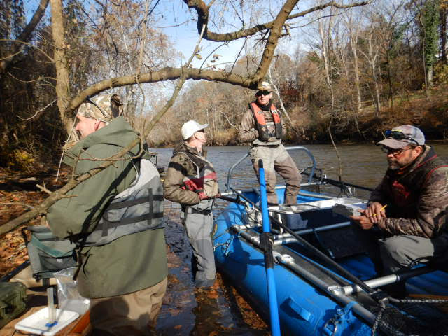 Le bateau bleu de pêche électrique et les quatre membres du personnel à terre après leur expédition. 