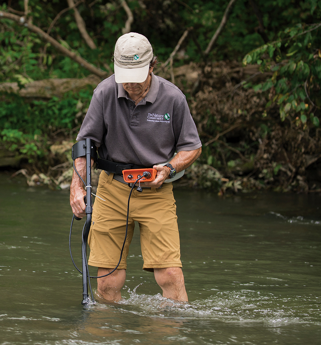 Image de Braven Beaty utilisant une baguette de détection pour rechercher les étiquettes PIT attachées aux coquilles des moules réintroduites afin de trouver leur emplacement.