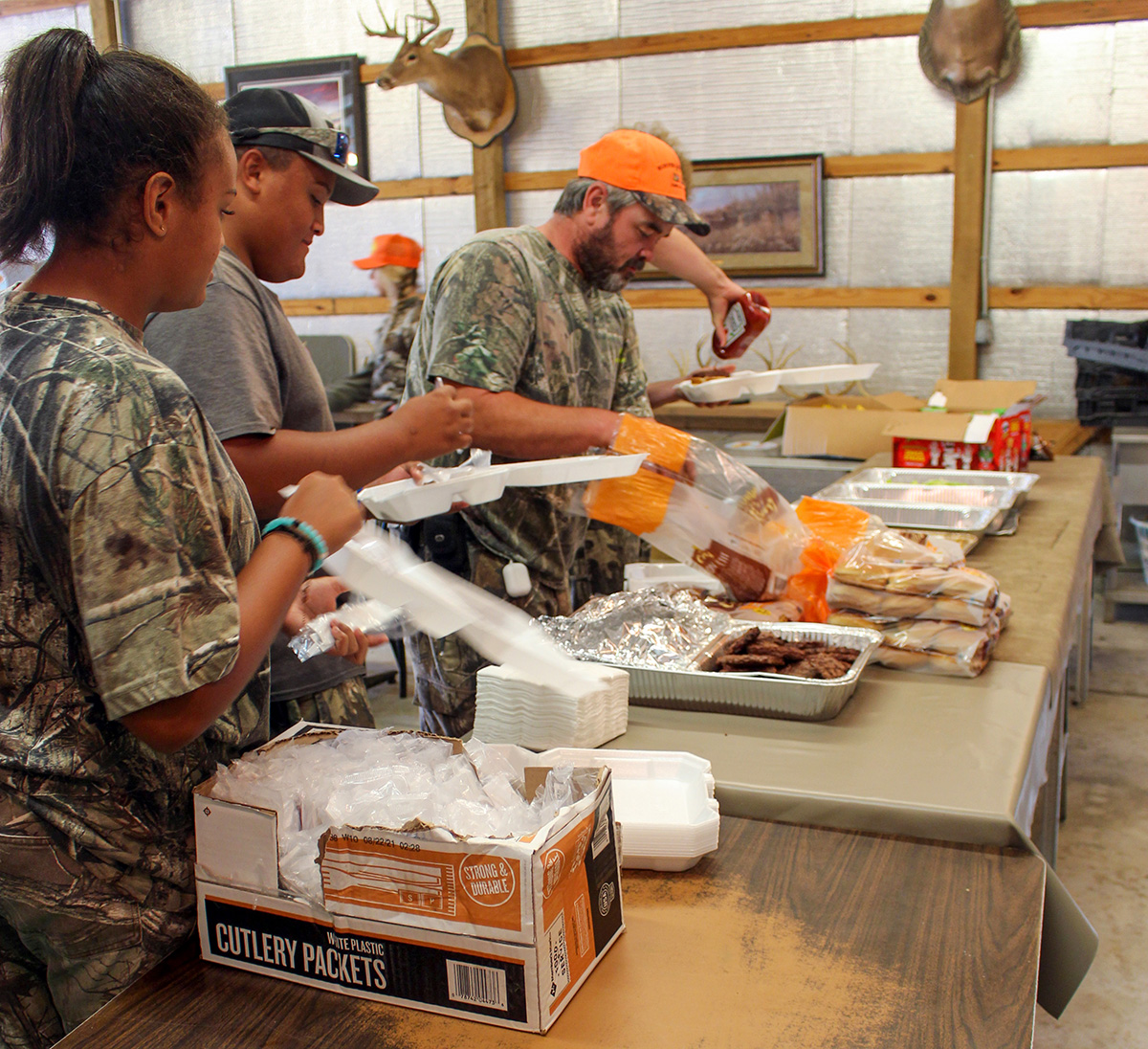 Une photo de trois personnes travaillant ensemble à la préparation d'un repas.