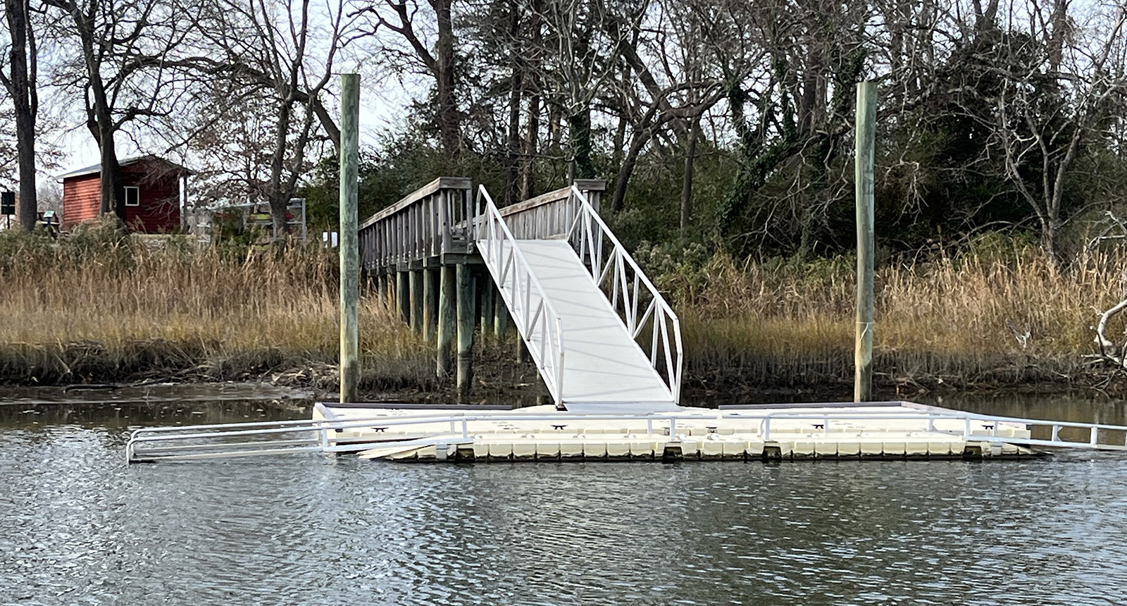 Photo d'une rampe de mise à l'eau de kayak en aluminium dépassant de la berge dans l'eau d'une rivière.