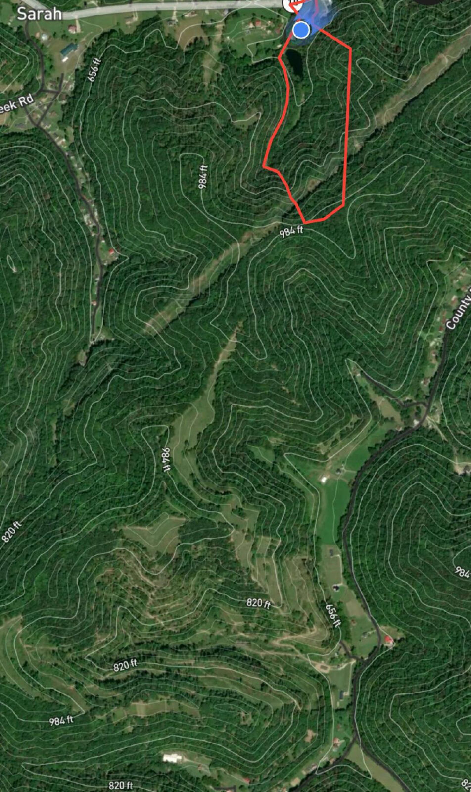 Image d'une carte aérienne d'une zone boisée et de champs ouverts.