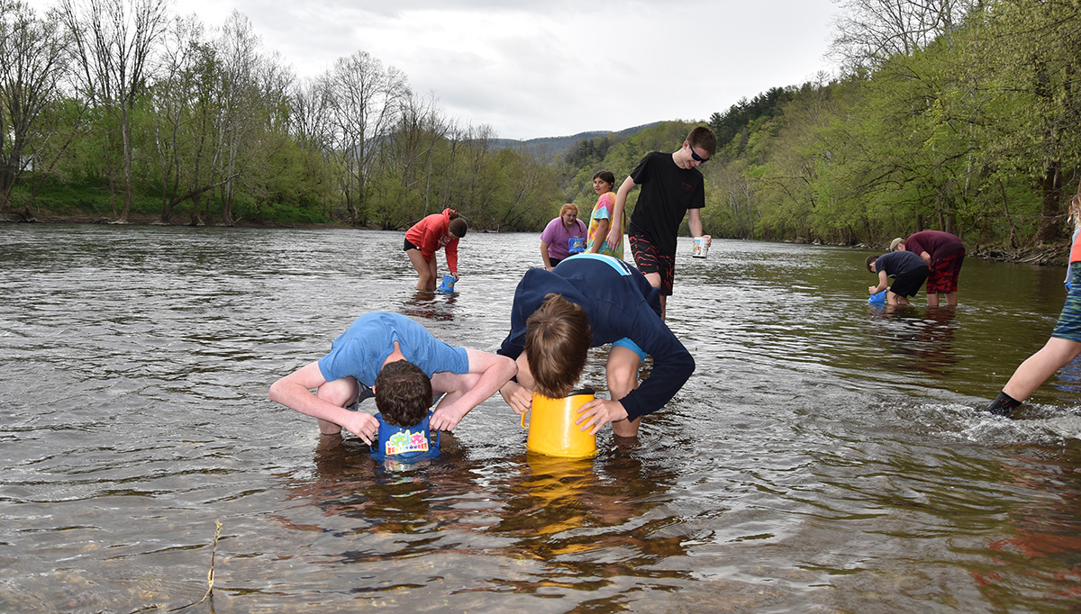 Image de plusieurs étudiants regardant l'eau avec des jumelles dans le cadre de la journée Project wild sur la rivière James.