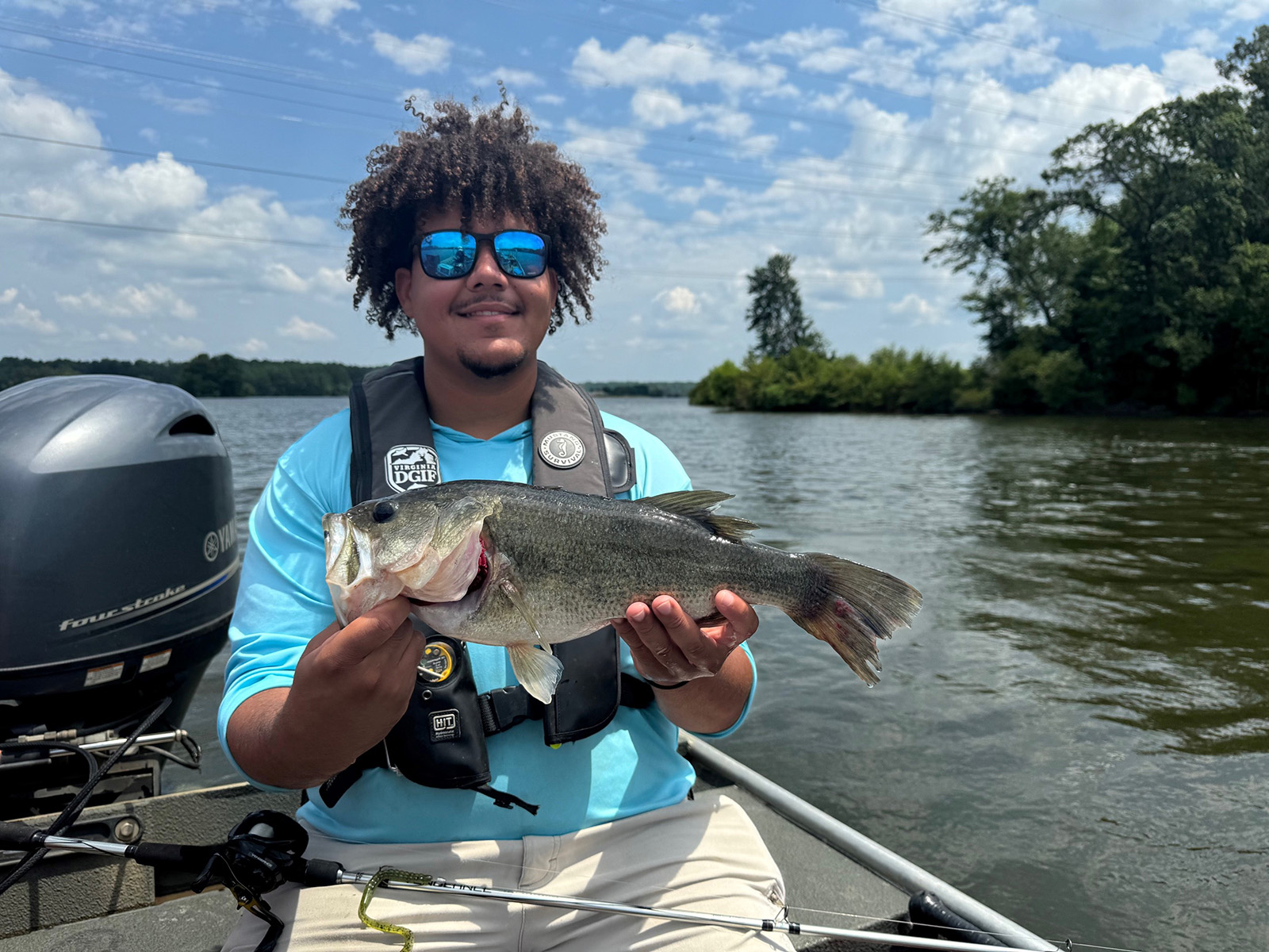 Une photo d'un homme assis dans un bateau, tenant un gros poisson.