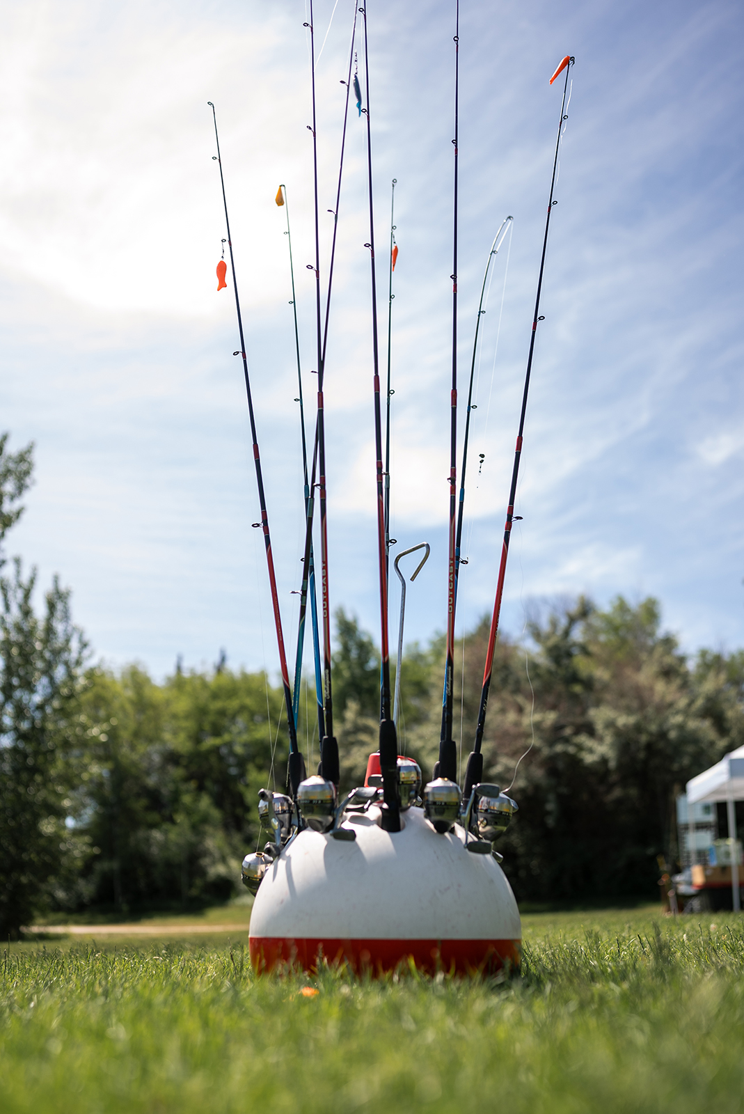 Une photographie représentant plusieurs cannes à pêche dépassant d'un support en forme de grand flotteur.
