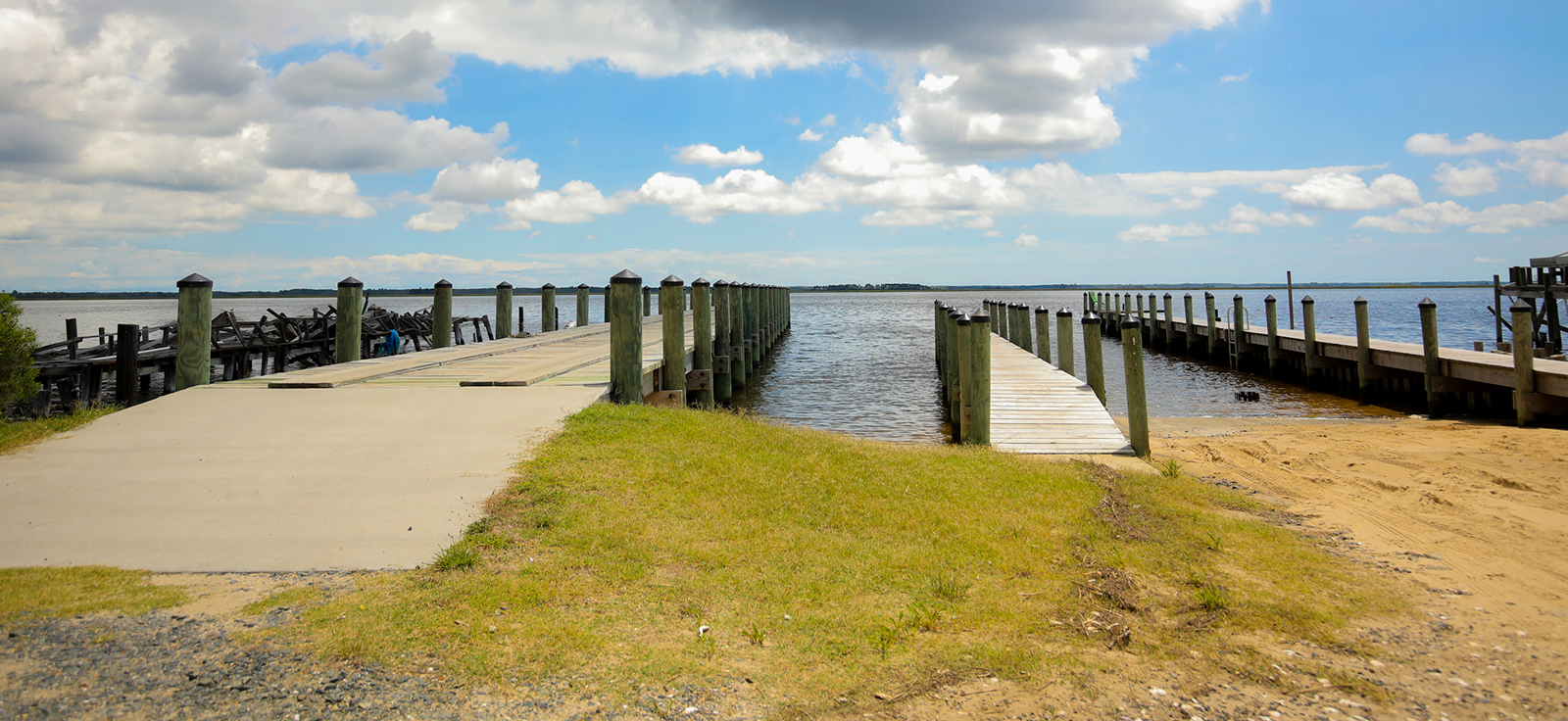 Photo d'une rampe de mise à l'eau à droite et d'un quai à gauche s'avançant dans l'eau.