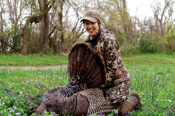 Image d'une fille posant avec une dinde morte