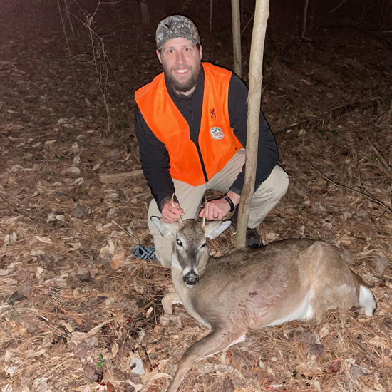 Une photo d'un homme en orange flamboyant agenouillé avec un mâle couché sur le sol devant lui,