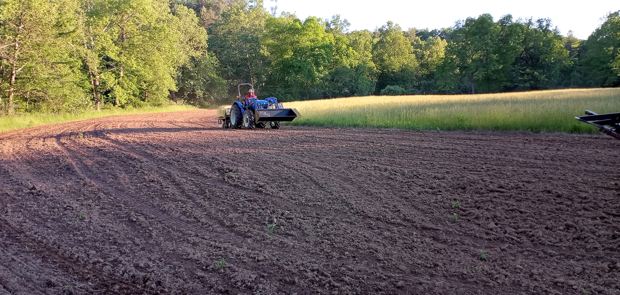 Image d'un tracteur en train de semer des graines pour le corridor faunique.