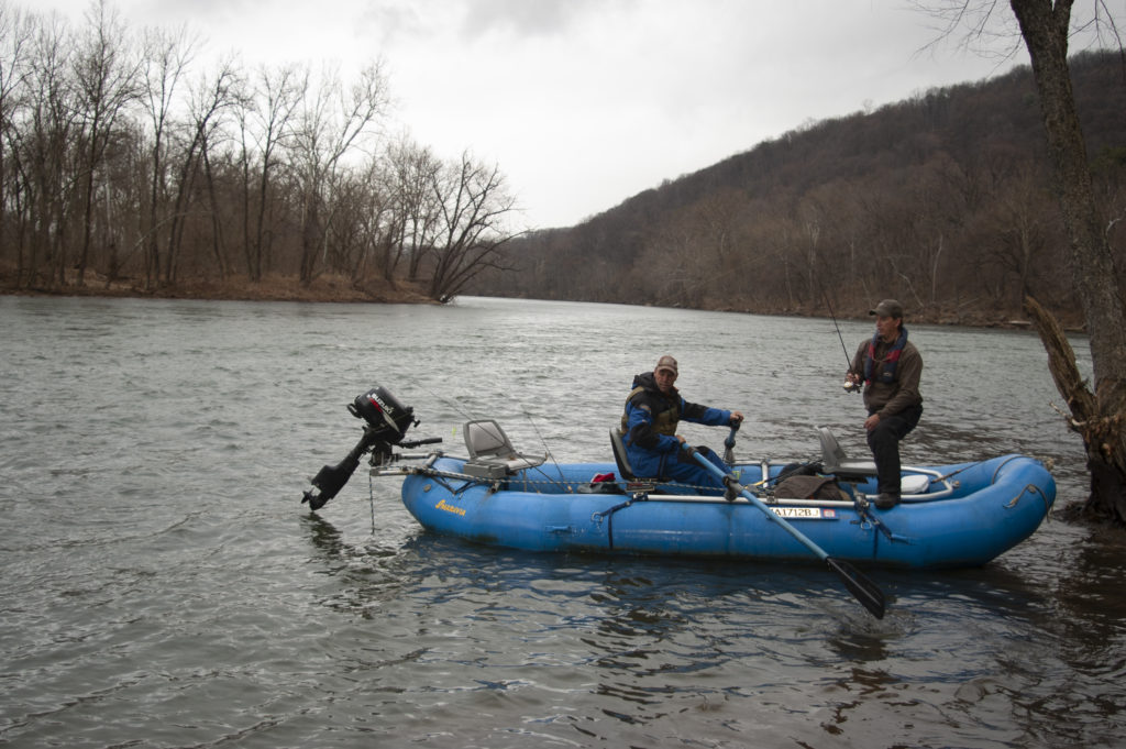 Une image de deux hommes dans un radeau bleu pêchant sur la rivière New.